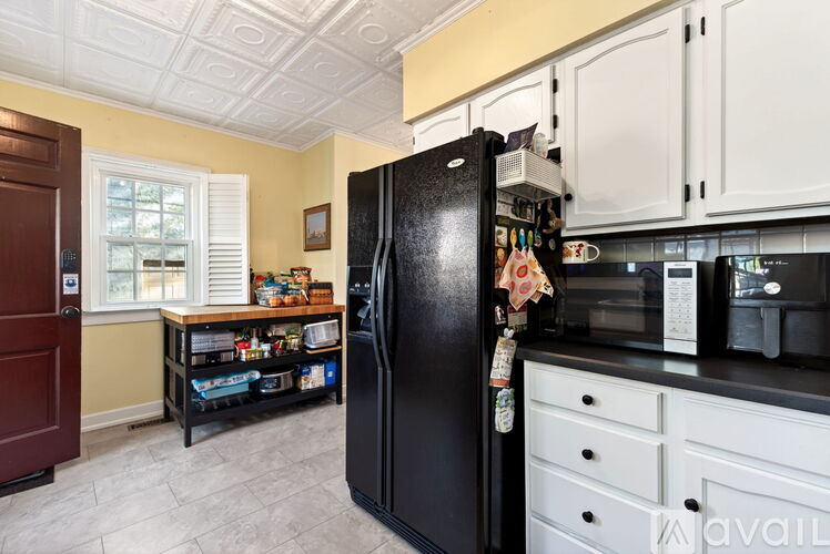 A black refrigerator with a magnet on it in a kitchen.