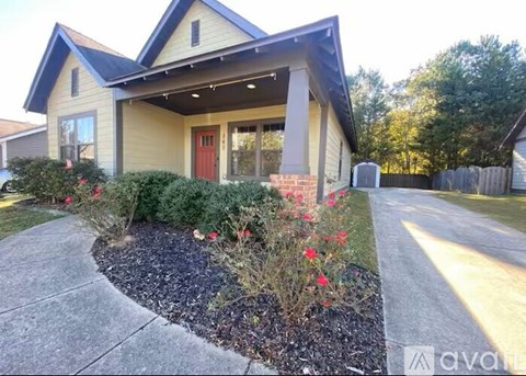 A house with a red door and a small garden in front.