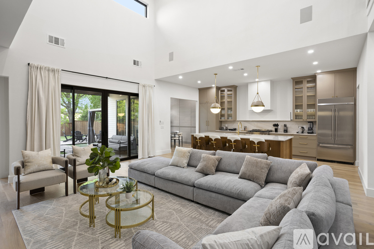 A modern living room with a grey sofa and a glass coffee table.