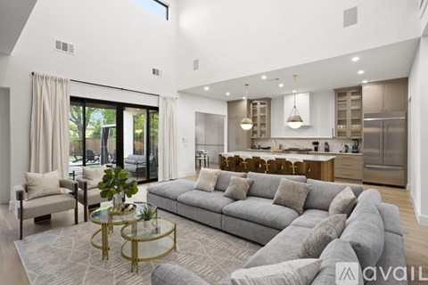 A modern living room with a grey sofa and a glass coffee table.