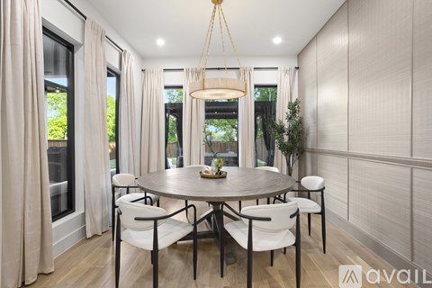 A modern dining room with a round table and chairs.