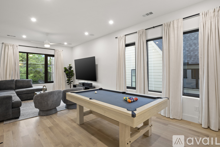 A pool table in a room with a television and a couch.