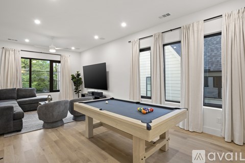 A pool table in a room with a television and a couch.