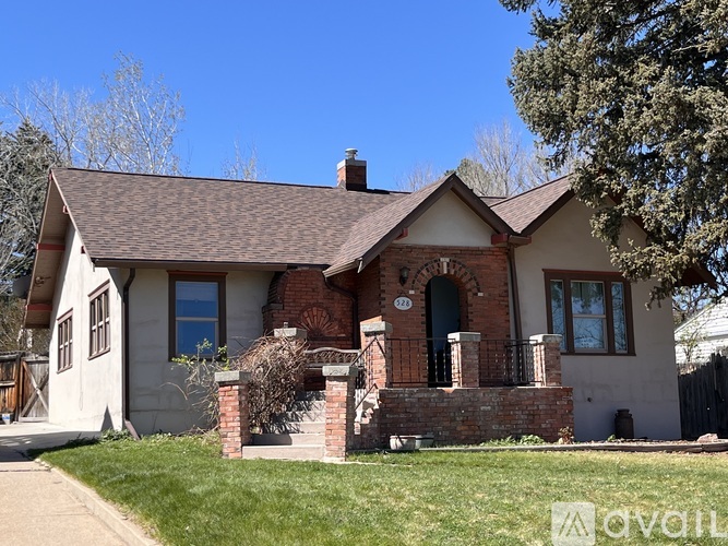 A house with a brown roof and a brick chimney is for sale.