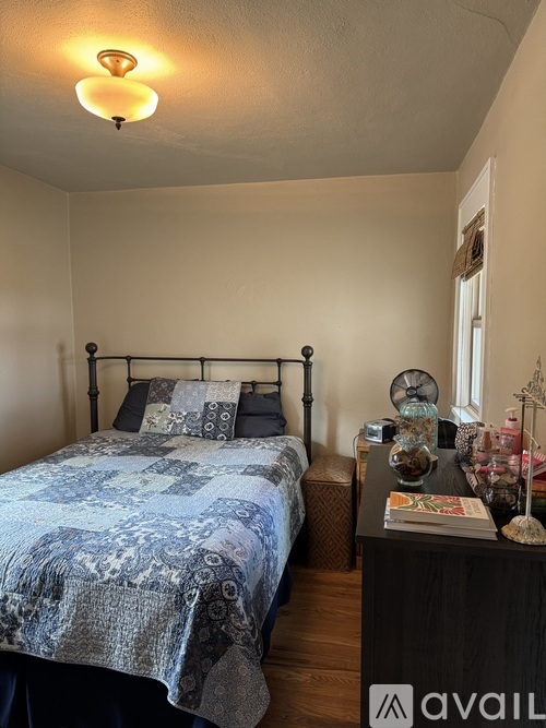 A bedroom with a bed, nightstand, and lamp.