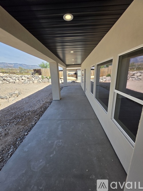 A long, narrow covered walkway with a view of a rocky landscape through the windows on the right.