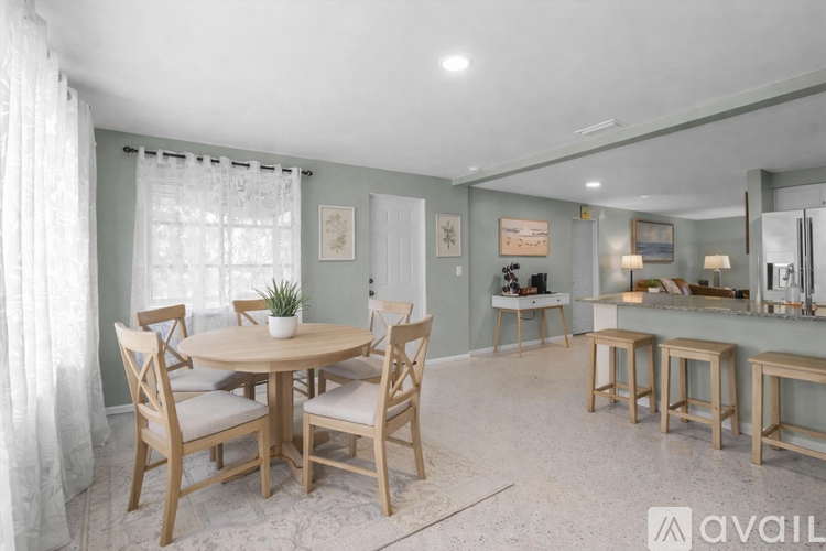 A dining room with a round table and chairs.