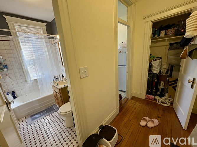 A bathroom with a white toilet and a white bathtub with a shower curtain.