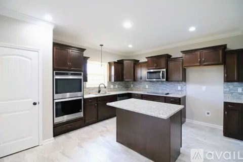A kitchen with dark brown cabinets and a white island.