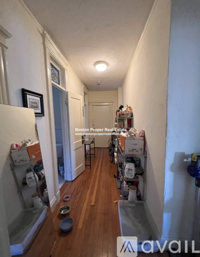 A long hallway with a sign that says "Boston Proper Real Estate.".