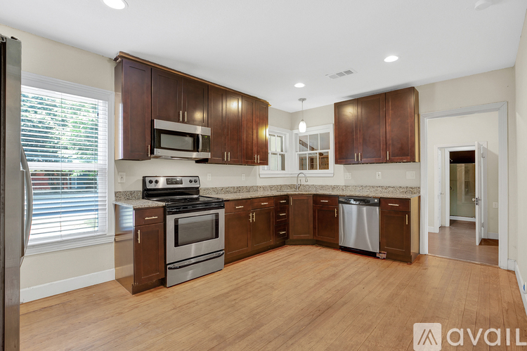 A kitchen with wooden cabinets and stainless steel appliances is available for rent.