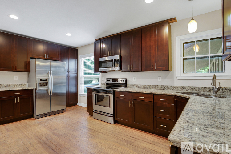 A kitchen with wooden cabinets and a marble countertop.