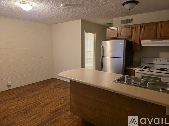 A kitchen area with a refrigerator, sink, and stove.