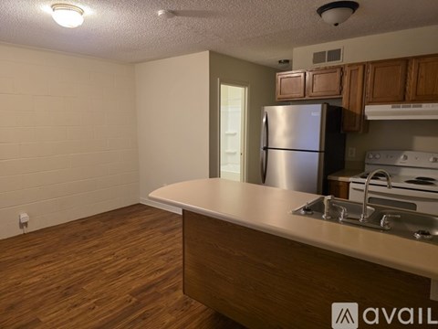 A kitchen area with a refrigerator, sink, and stove.