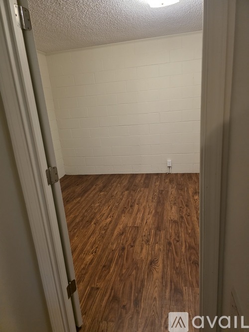 A room with wooden flooring and white walls.