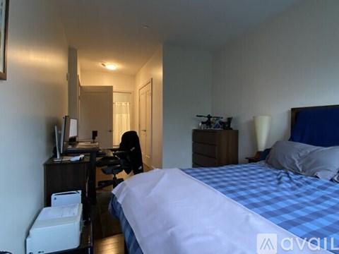 A bedroom with a bed, desk, and chair.