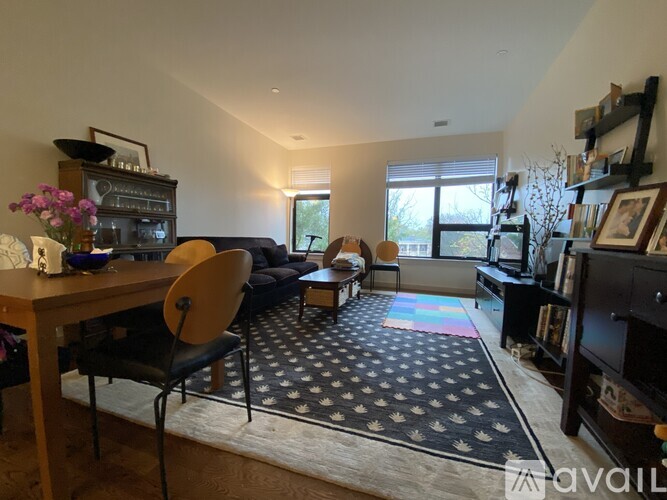A living room with a black and white rug and a wooden table.
