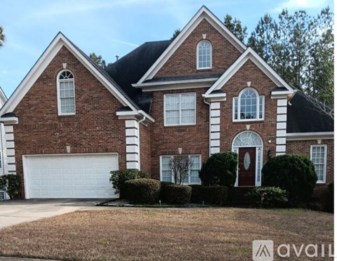 A brick house with a white garage door and a red door.