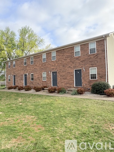 A brick building with a green lawn in front.