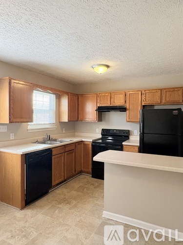 A kitchen with wooden cabinets and black appliances.