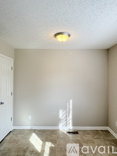 A room with a white door and a light on the ceiling.