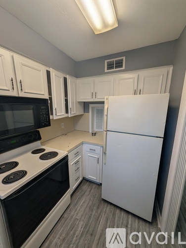 A kitchen with white appliances and cabinets.
