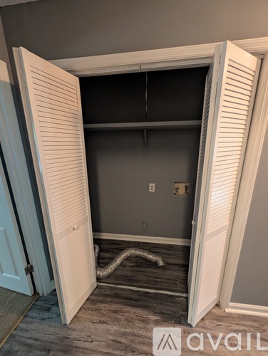 A room with a white door is open to a dark room.