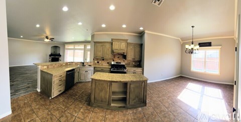 A kitchen with a tile floor and a ceiling fan.