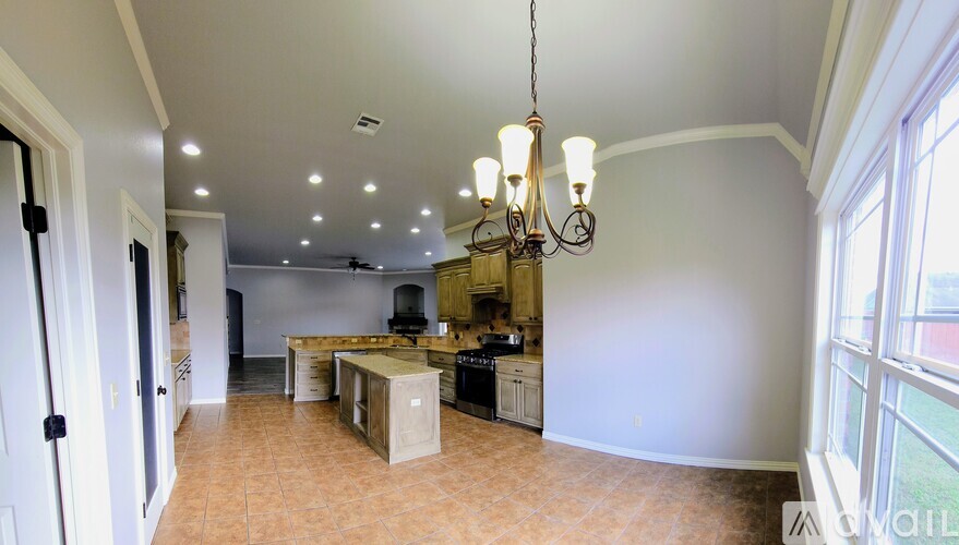 A kitchen with a tile floor and a chandelier hanging from the ceiling.