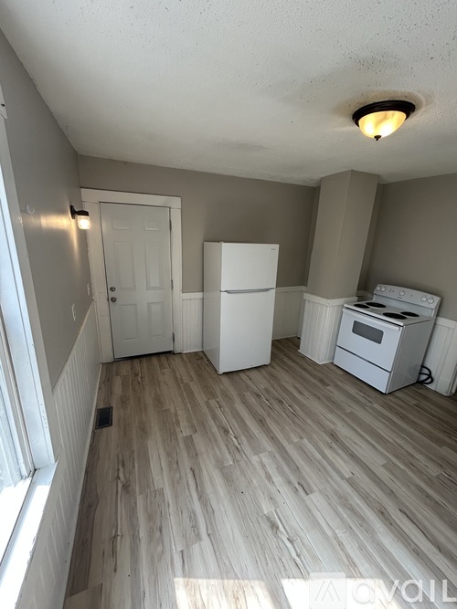 A room with a white fridge, a white washing machine and a white dishwasher.