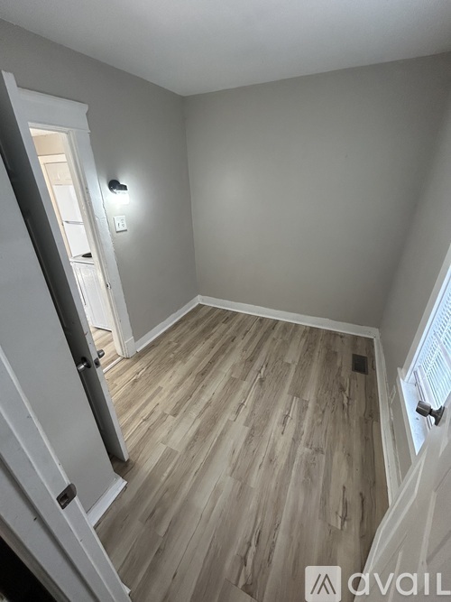 A room with wooden flooring and a white door.