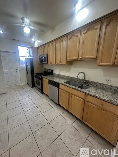 A kitchen with wooden cabinets and a granite countertop.