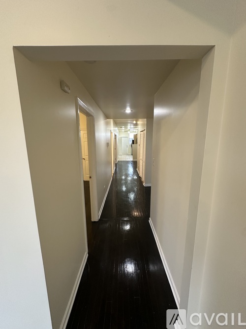 A long hallway with a black floor and white walls.