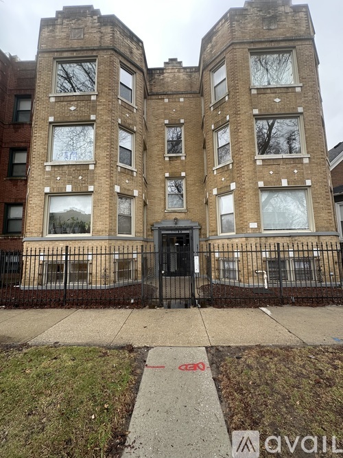 A tall brick building with a black gate in front.