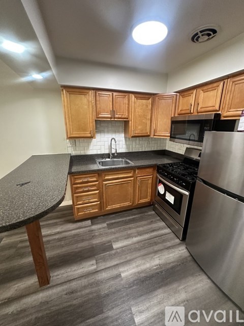 A kitchen with wooden cabinets and a granite countertop.