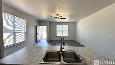 A kitchen with a sink and a ceiling fan.