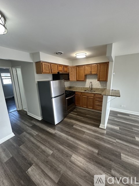 A kitchen with wooden cabinets and a refrigerator.