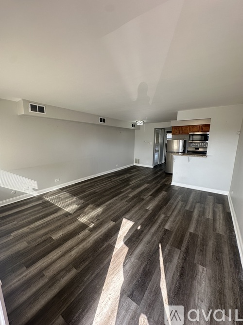A room with wooden flooring and a white wall.
