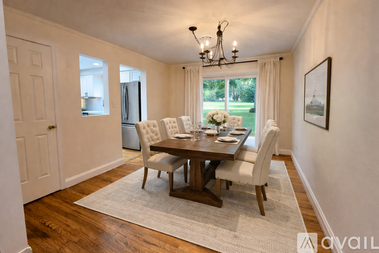 A dining room with a wooden table and chairs.