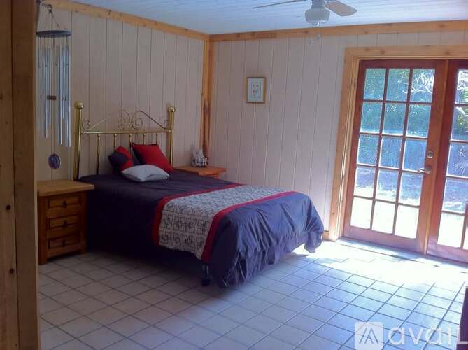 A bedroom with a bed, dresser, and window.