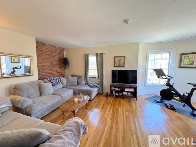 A living room with a grey couch and a wooden floor.