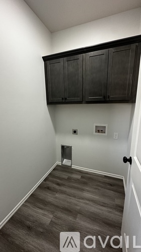 A room with a white wall and a black cabinet.