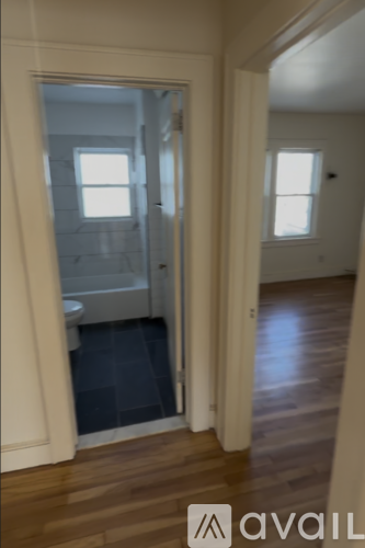A bathroom with a toilet and sink is visible through a doorway.