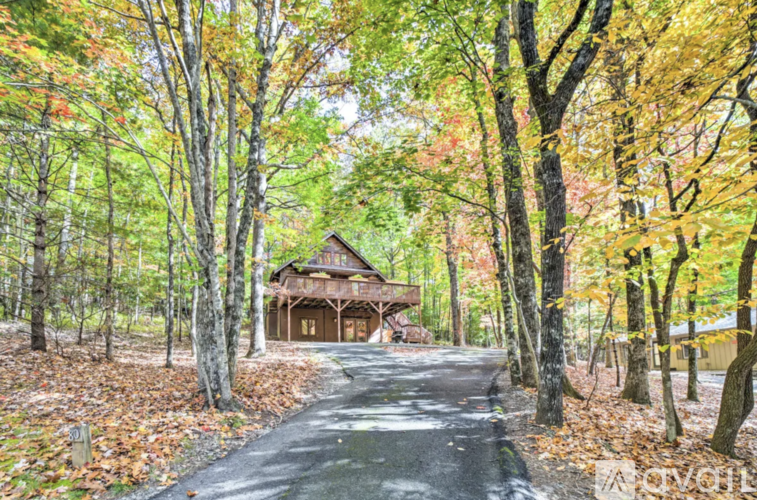 A house is surrounded by trees with autumn leaves.