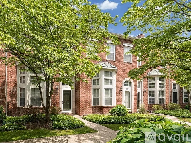 A row of red brick houses with green trees in front.