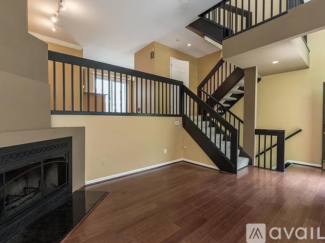 A spacious living room with a fireplace and a staircase.