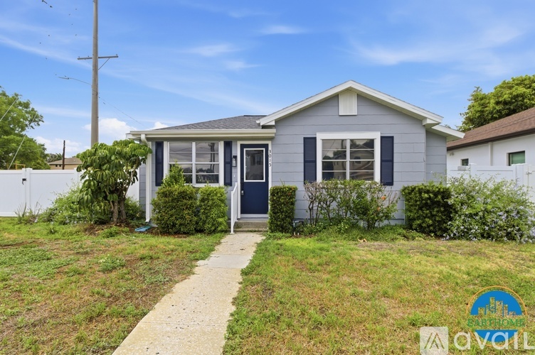 A small house with a blue door and a sign that says "Avalon" in front of it.