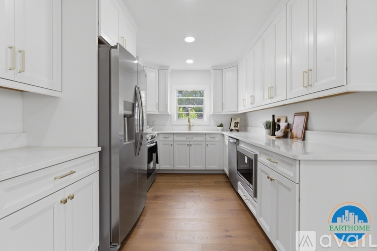 A kitchen with white cabinets and a stainless steel refrigerator.
