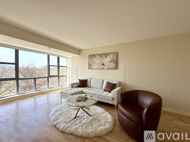 A living room with a brown leather chair and a white sofa.