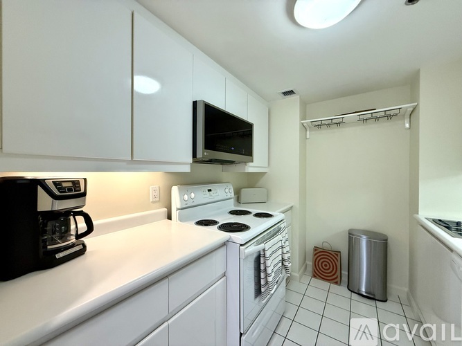A kitchen with white cabinets and appliances.